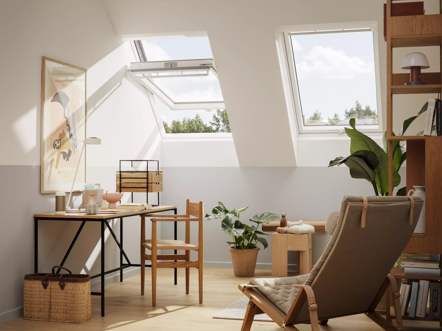 Attic workspace with sloped ceiling and VELUX roof windows, natural light entering.