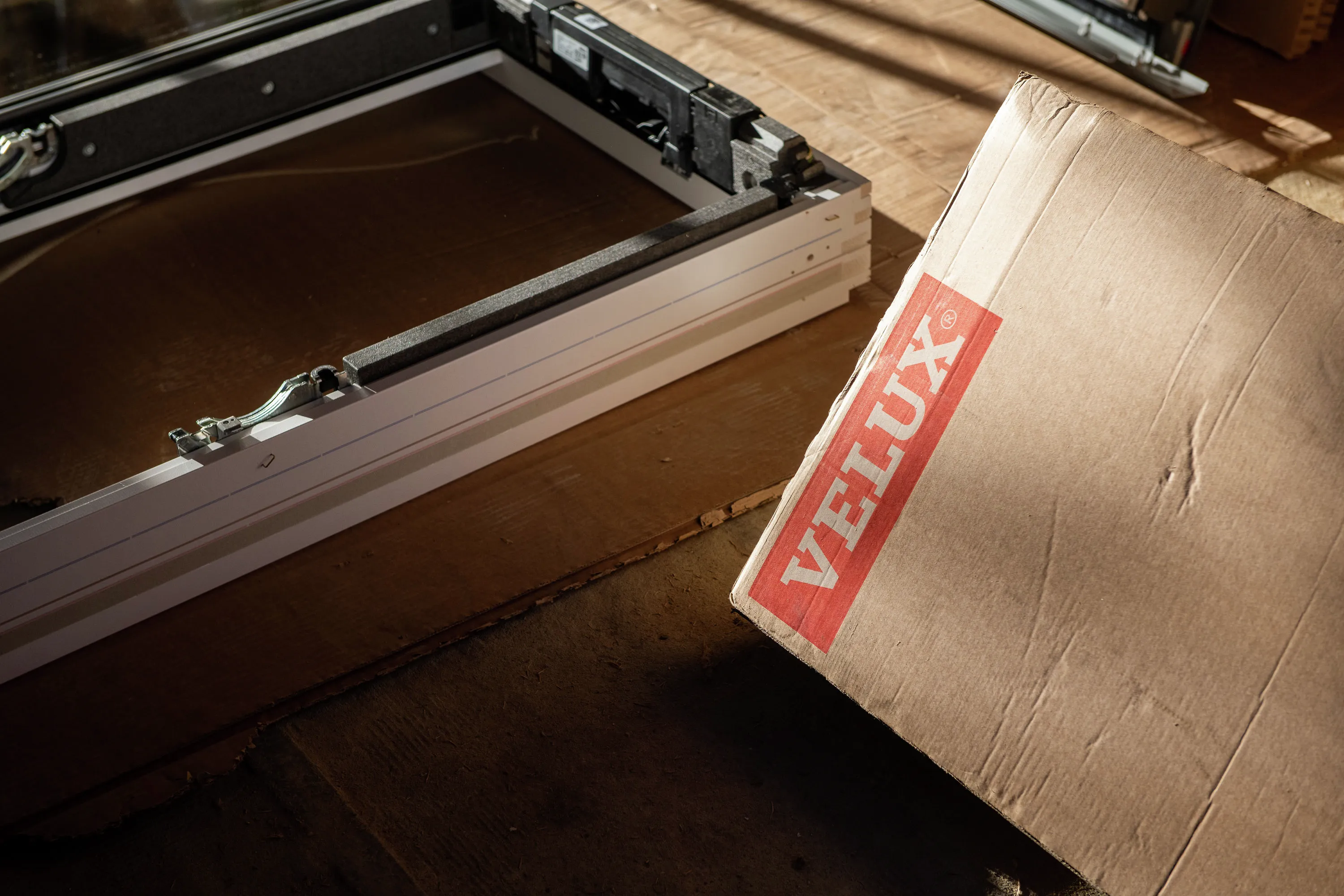 Close-up of VELUX roof window packaging on wooden surface.