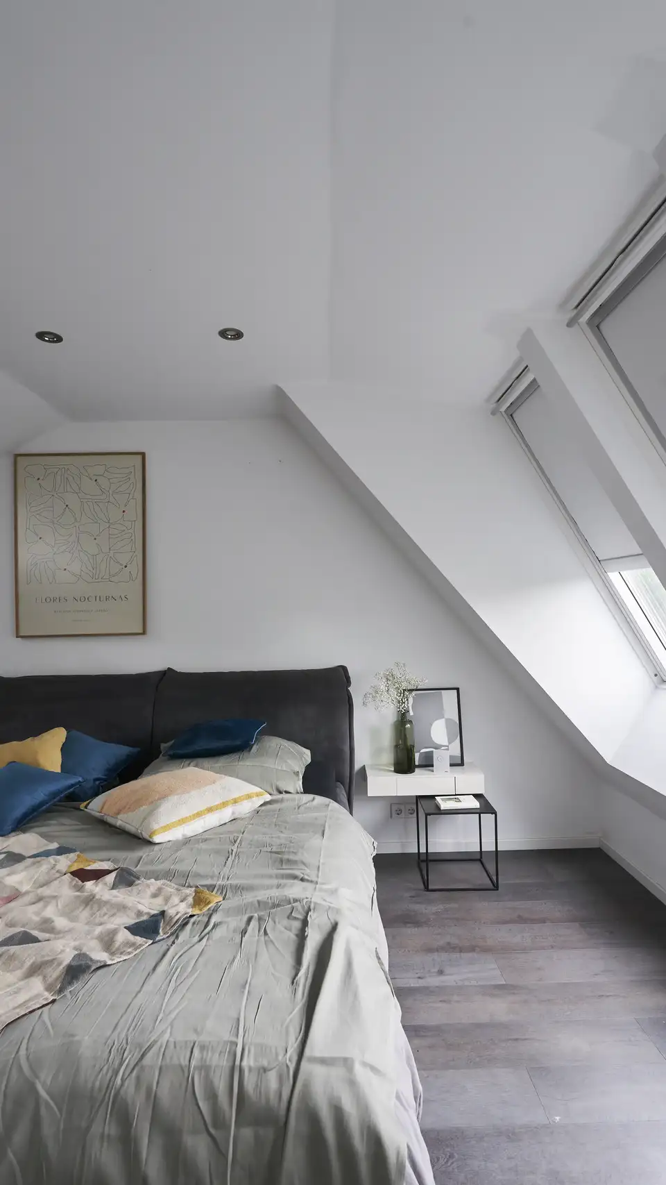 chambre mansardée avec deux fenêtres de toit VELUX, stores occultants et lit avec linge léger