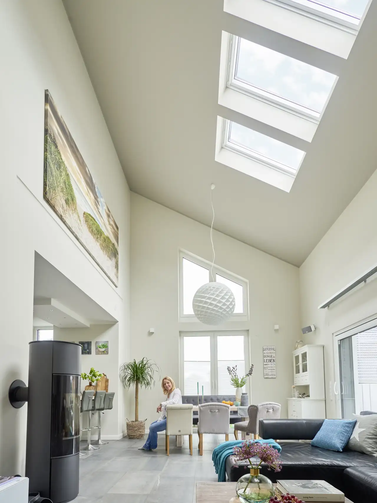 Wohnzimmer mit Wohnlandschaft überdacht von einem Pultdach mit grossen Dachfenstern  | VELUX Magazin