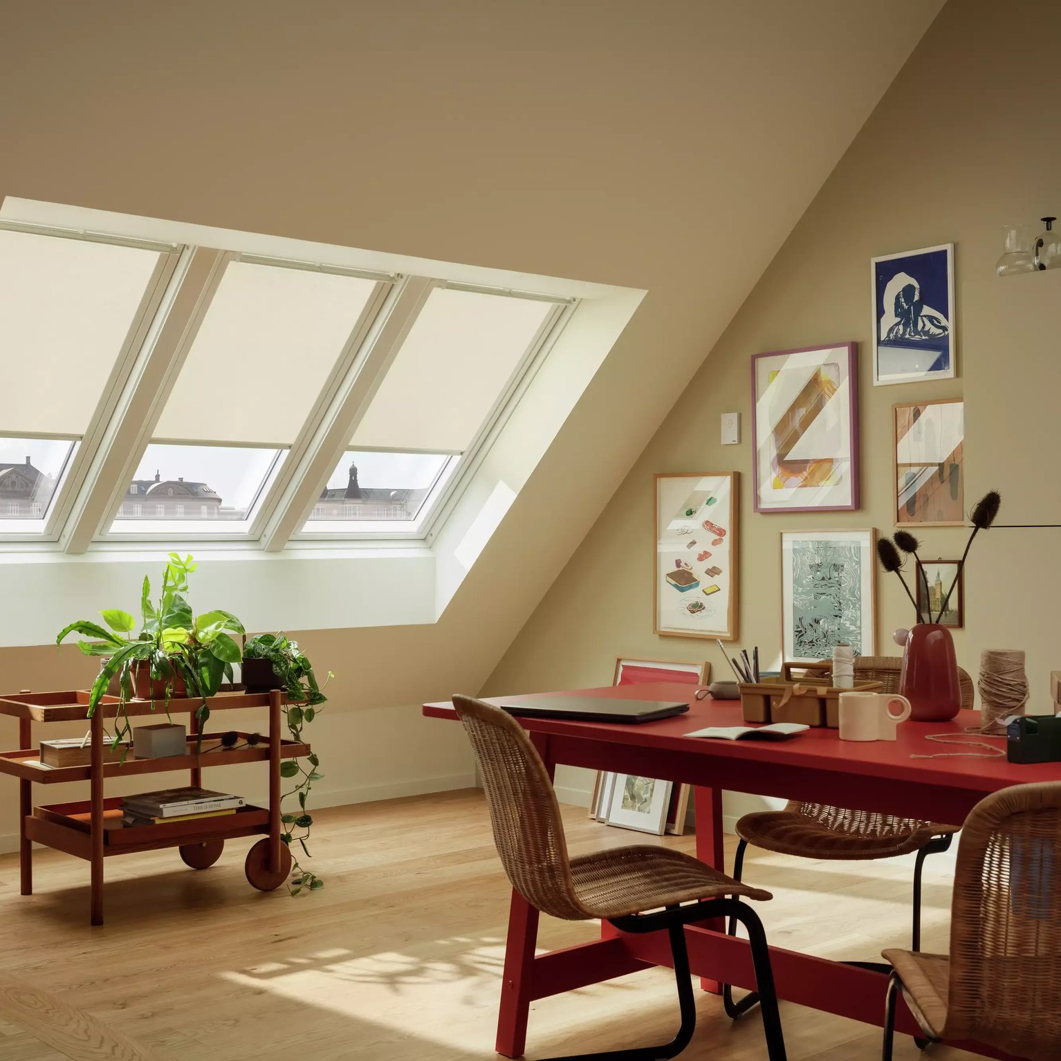 Attic workspace with sloped ceiling and VELUX roof windows, bright and creative.