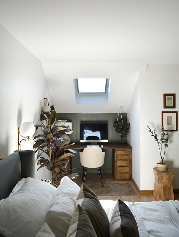 Attic home office with sloped ceiling and VELUX roof window.