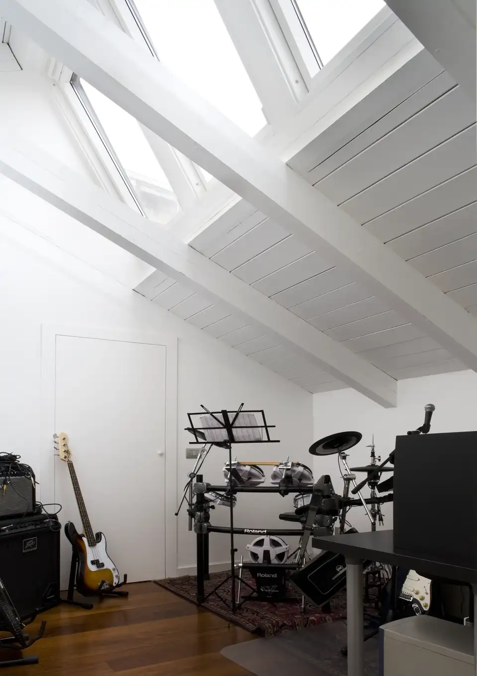 Coin musique sous combles avec instruments, éclairé par plusieurs fenêtres de toit VELUX. 