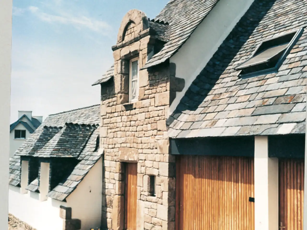 ancienne ferme en pierre rénovée avec toiture ardoise et fenêtres de toit VELUX
