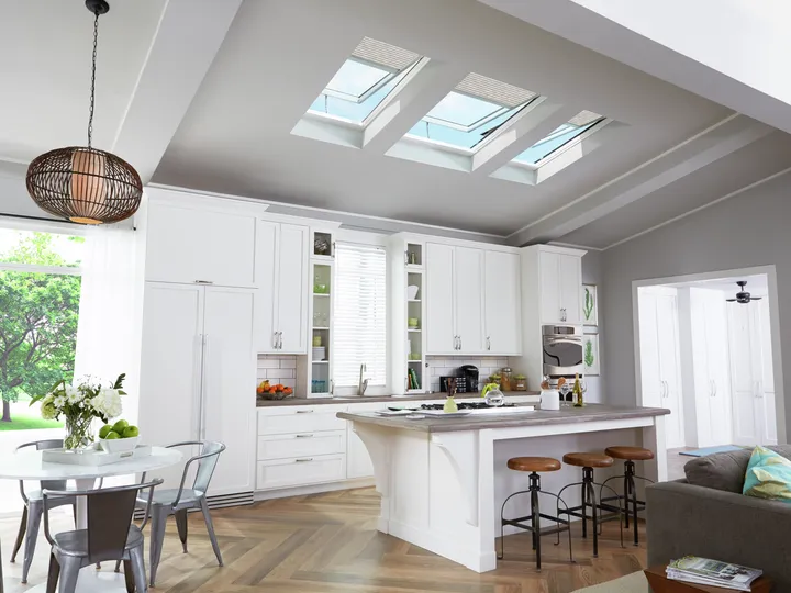 Modern kitchen with white cabinets and VELUX roof windows, bright and airy.