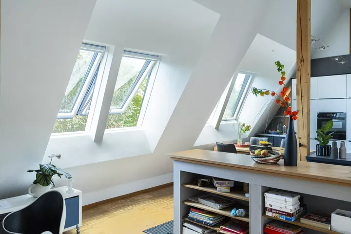 Moderne Küche mit glänzenden Schränken und einem VELUX Dachflächenfenster, das Sonnenlicht hereinlässt.