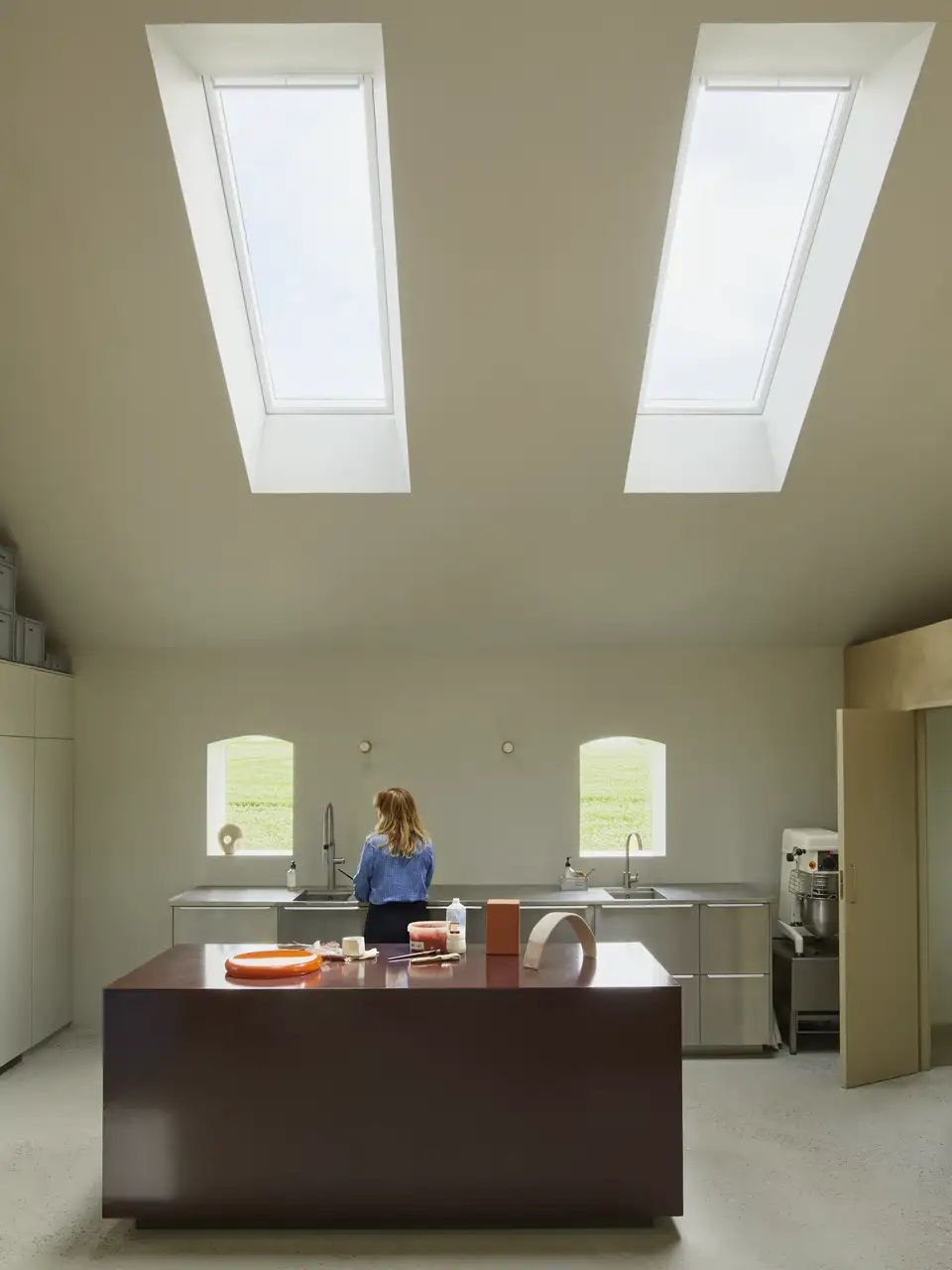 Vista frontale di una cucina sotto un tetto inclinato con due ampie finestre per tetti VELUX 