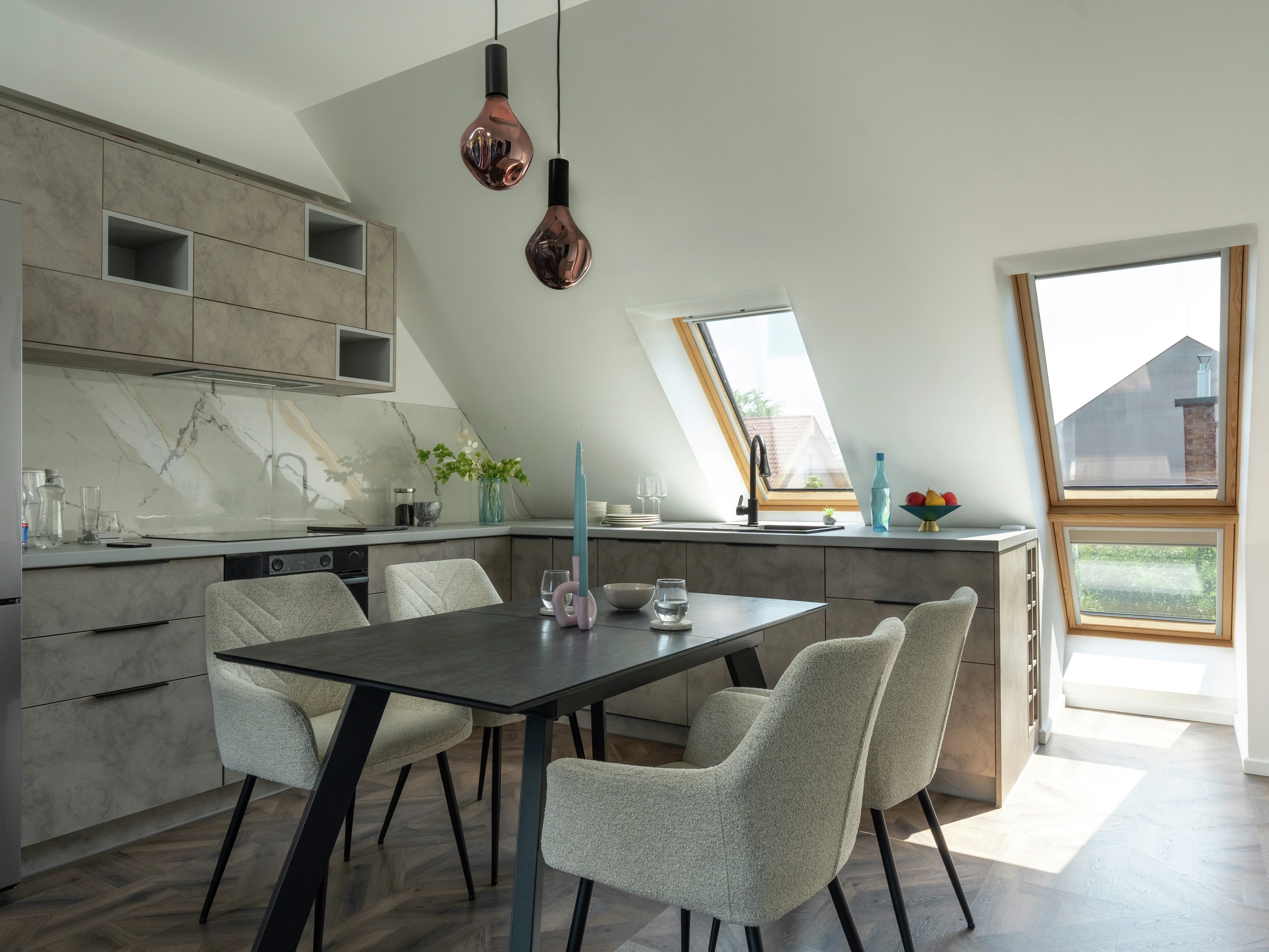 Attic kitchen with sloped ceiling and VELUX roof windows, modern design.