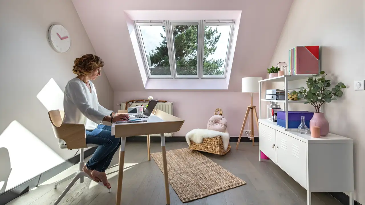 Bureau sous combles lumineux avec fenêtre de toit. 