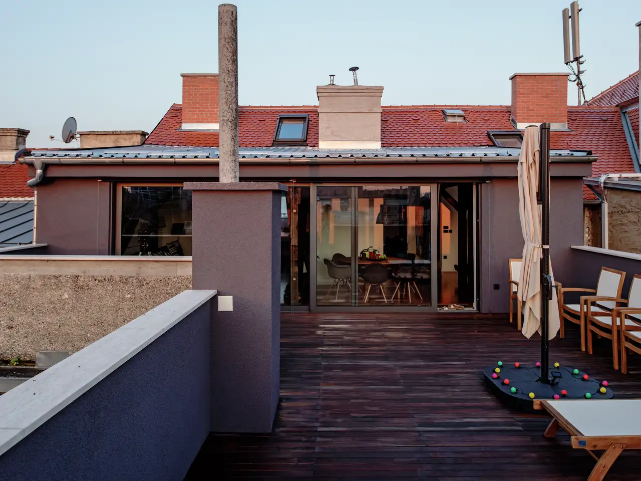 terrasse sur toit plat avec sol en bois, parasols, chaises et transats 