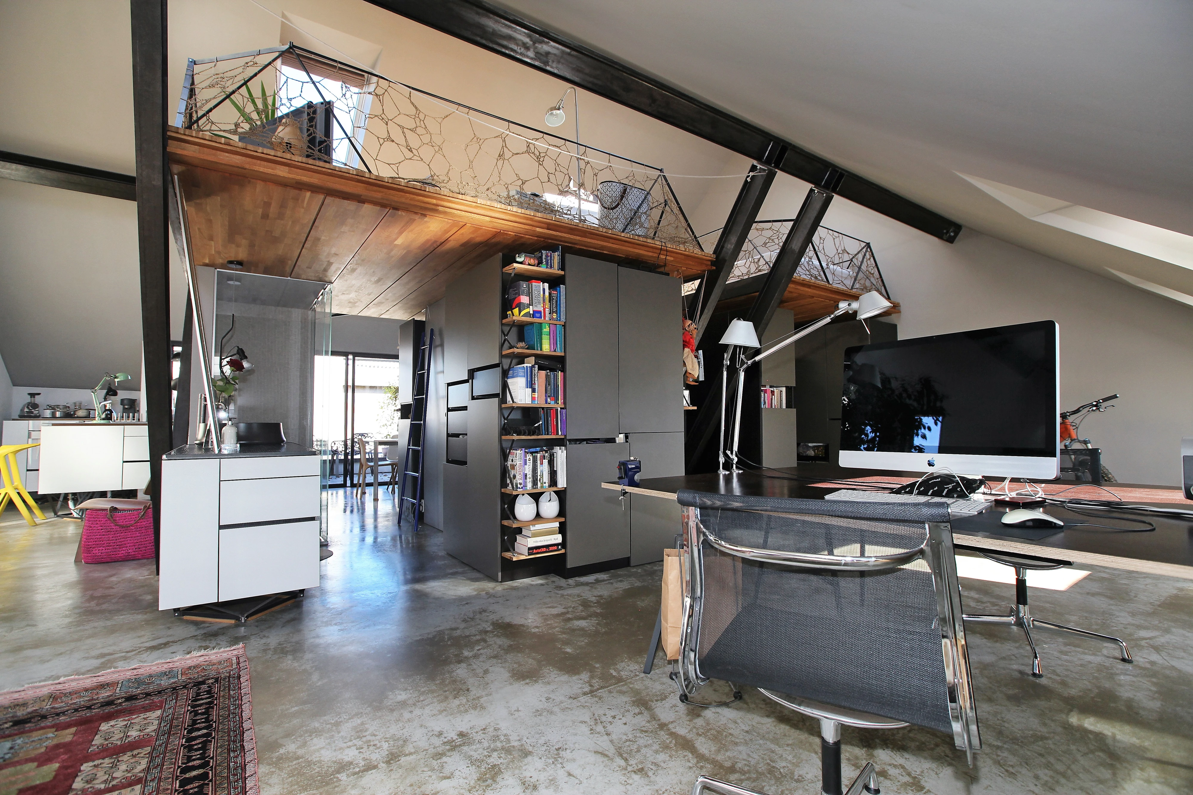 Contemporary attic workspace with sloped ceiling and VELUX roof window.