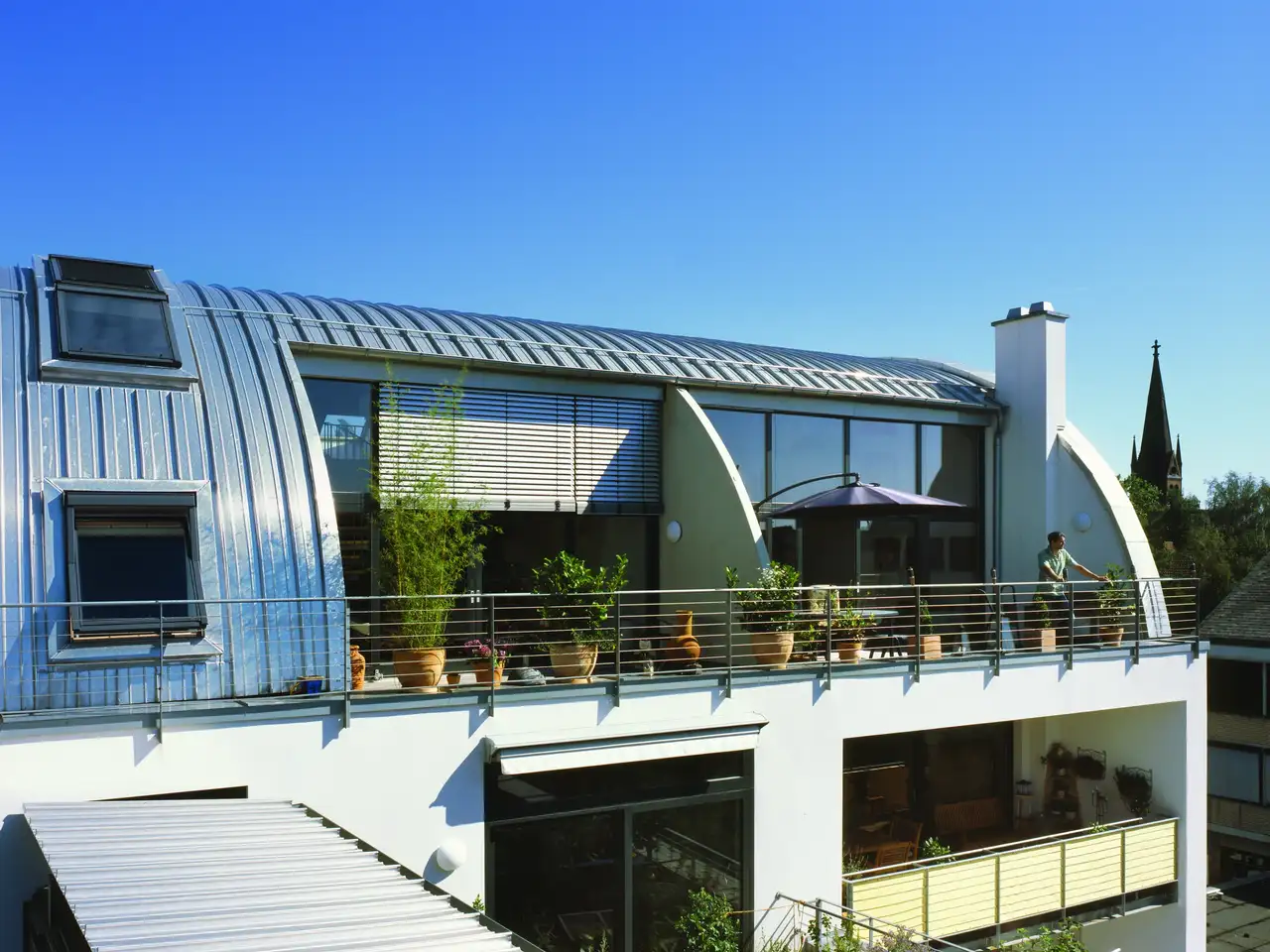 Dachbalkon im blechernen Tonnendach mit Grünpflanzen | VELUX Magazin