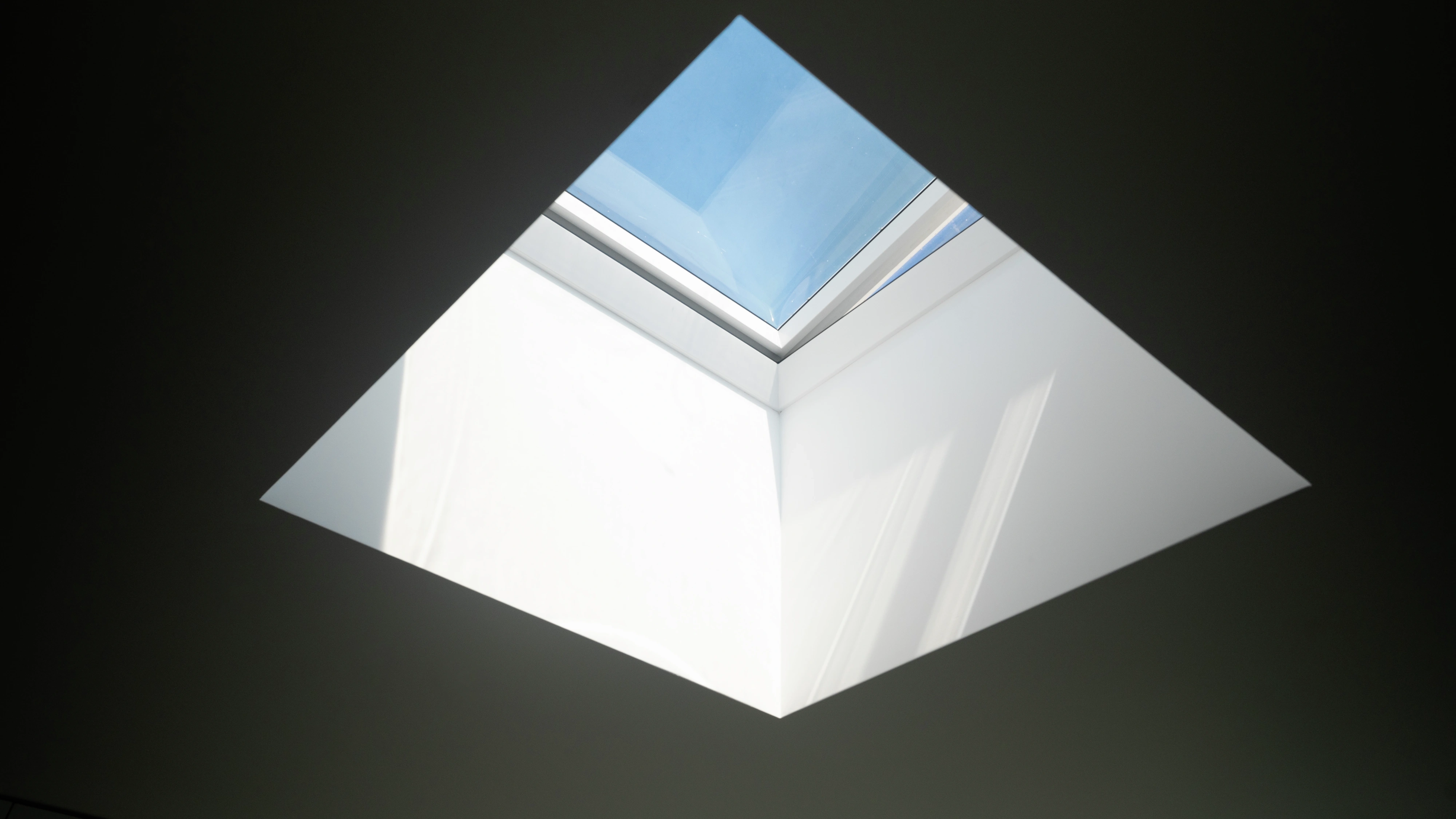 Square VELUX flat roof window bringing daylight through a deep white ceiling shaft.