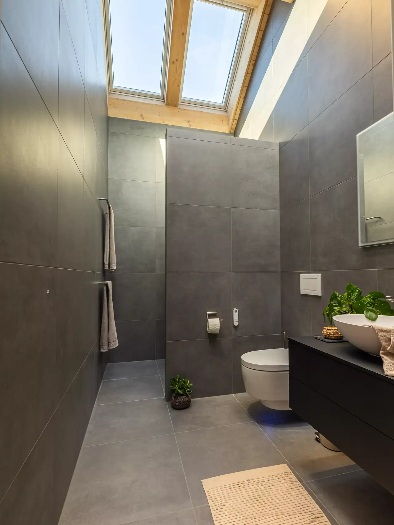 Un bagno in mansarda con finestre per tetti VELUX che aiutano a far fuoriuscire l’umidità