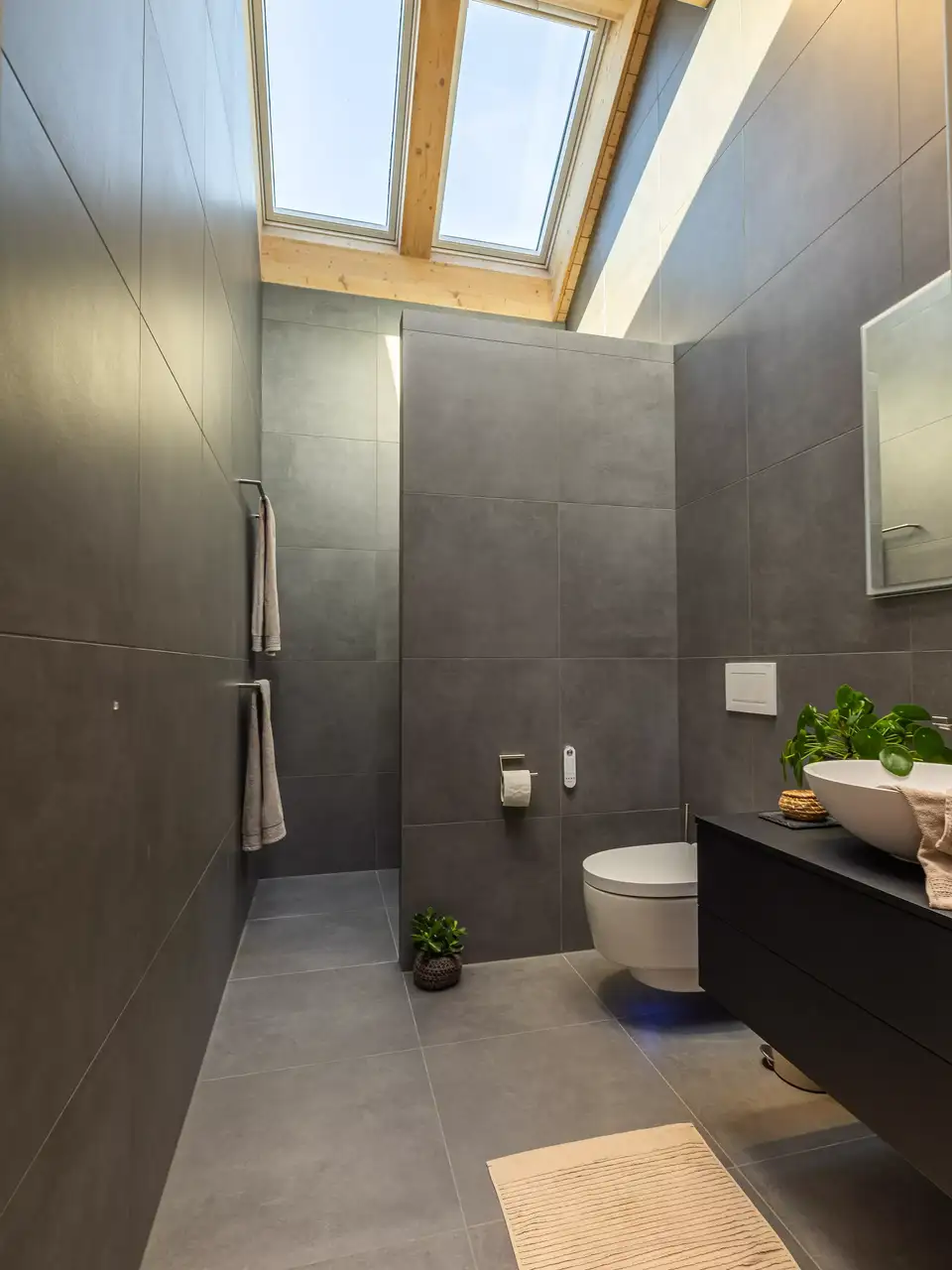 une salle de bain sous les toits évacue l’humidité par ses fenêtres de toit VELUX 