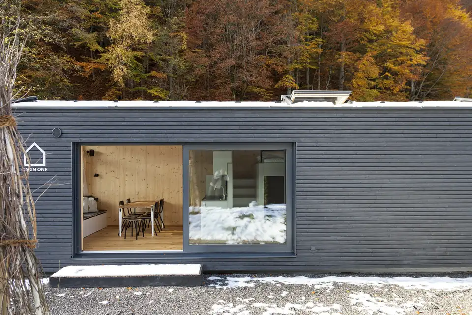 chalet contemporain au toit plat, large baie vitrée verticale et fenêtre pour toit plat VELUX