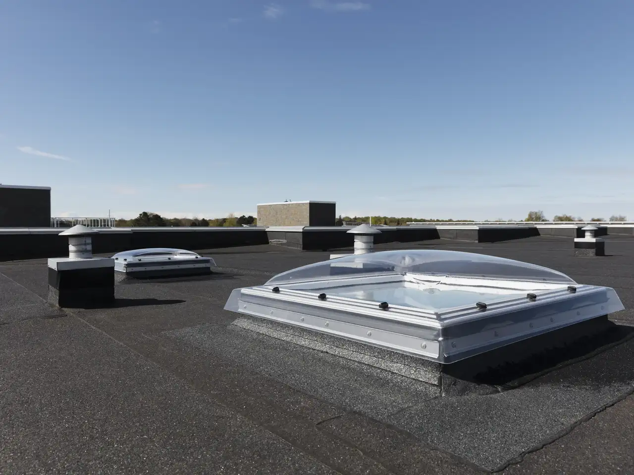 Tetto piano con finestre a cupola VELUX e piccoli comignoli