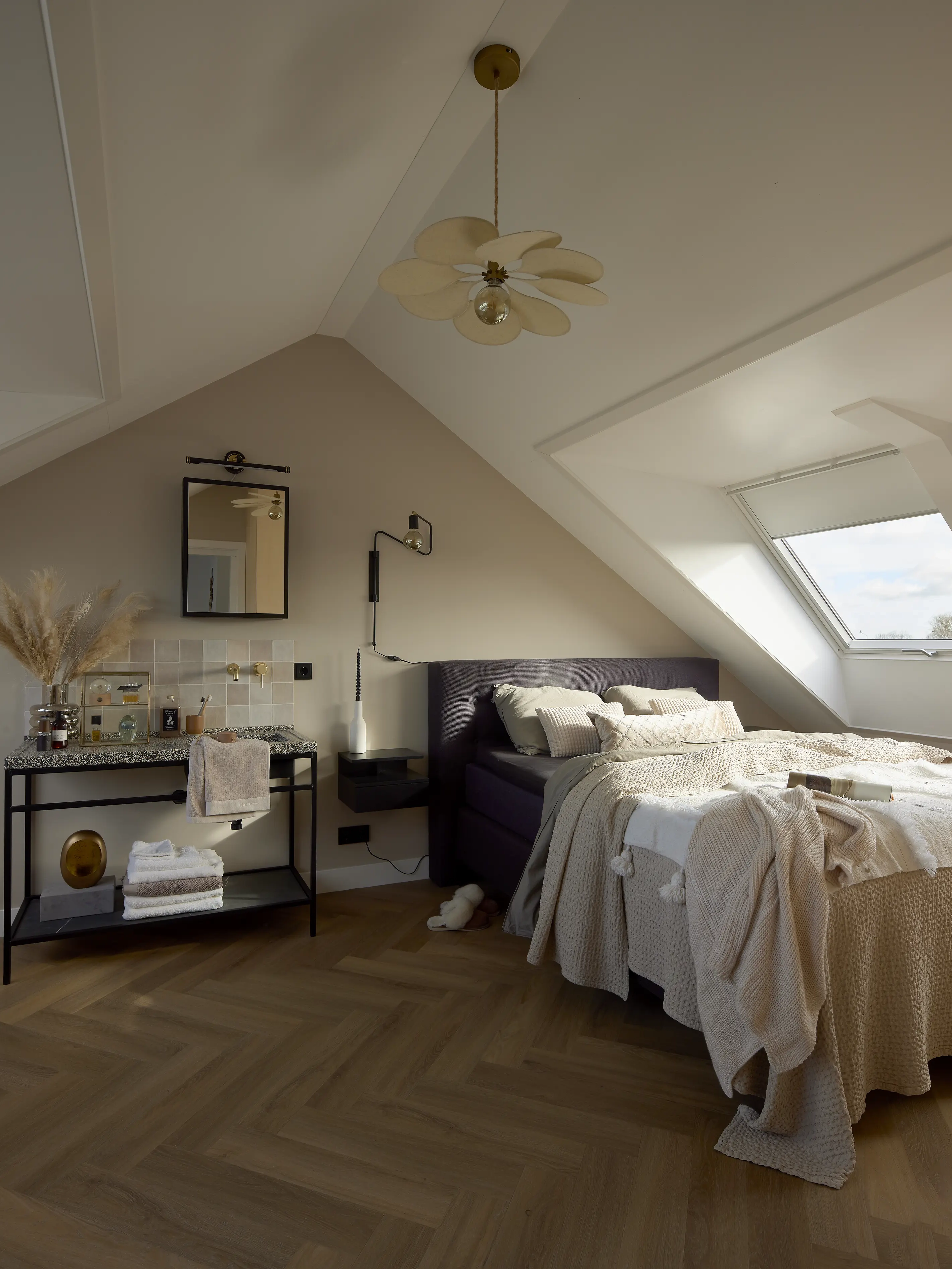Attic bedroom with sloped ceiling and VELUX roof window, cozy and bright. 