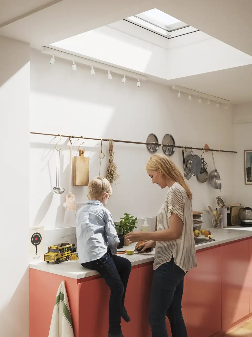 Modern kitchen with red cabinets and VELUX roof window, bright and welcoming.