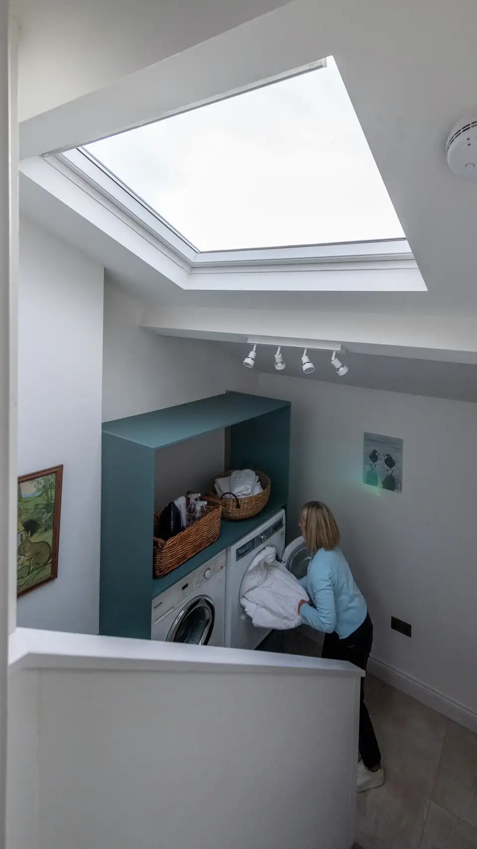 coin buanderie aménagé dans la niche d'un escalier, avec fenêtre de toit VELUX