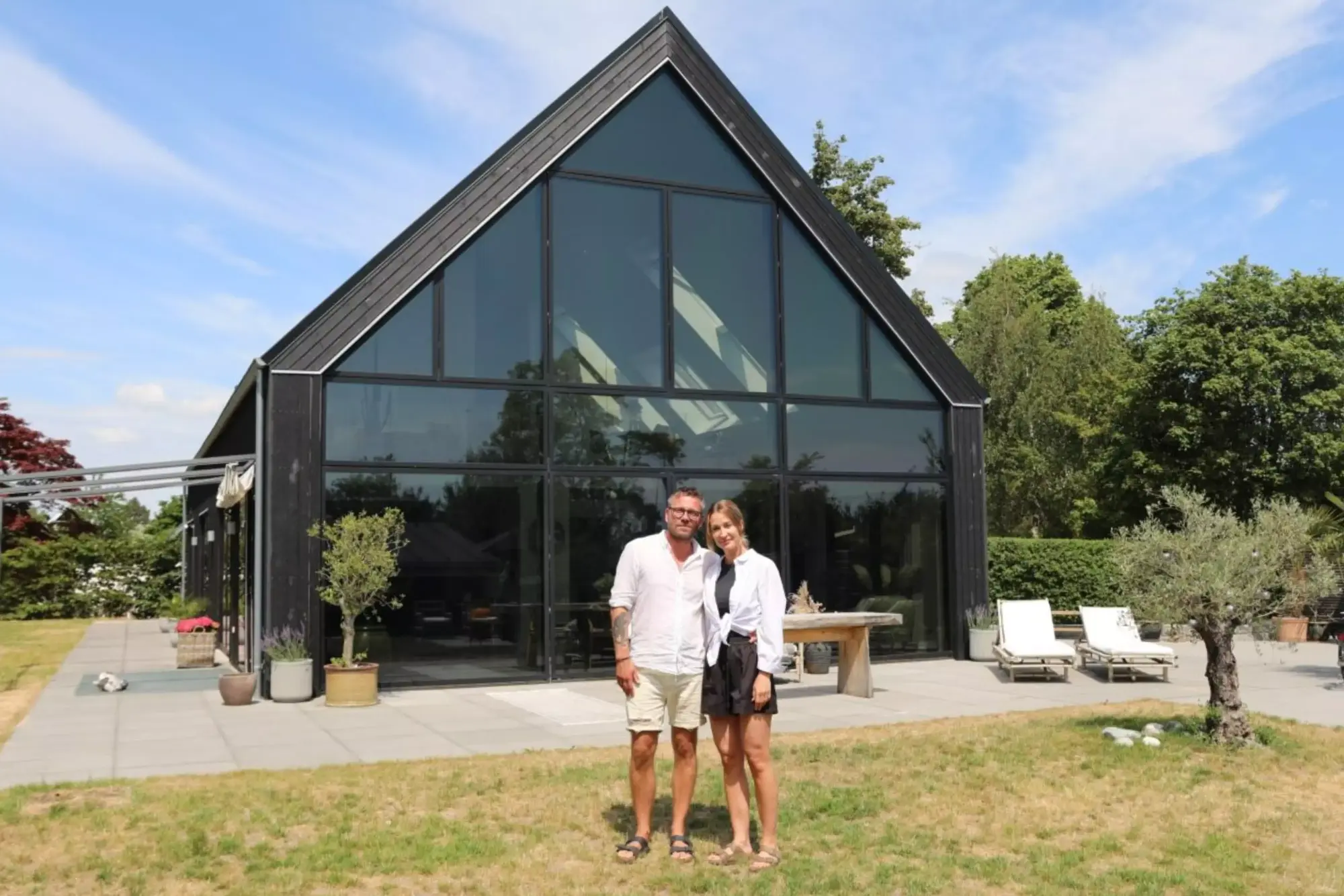 Man and woman standing in front of their home in Denmark