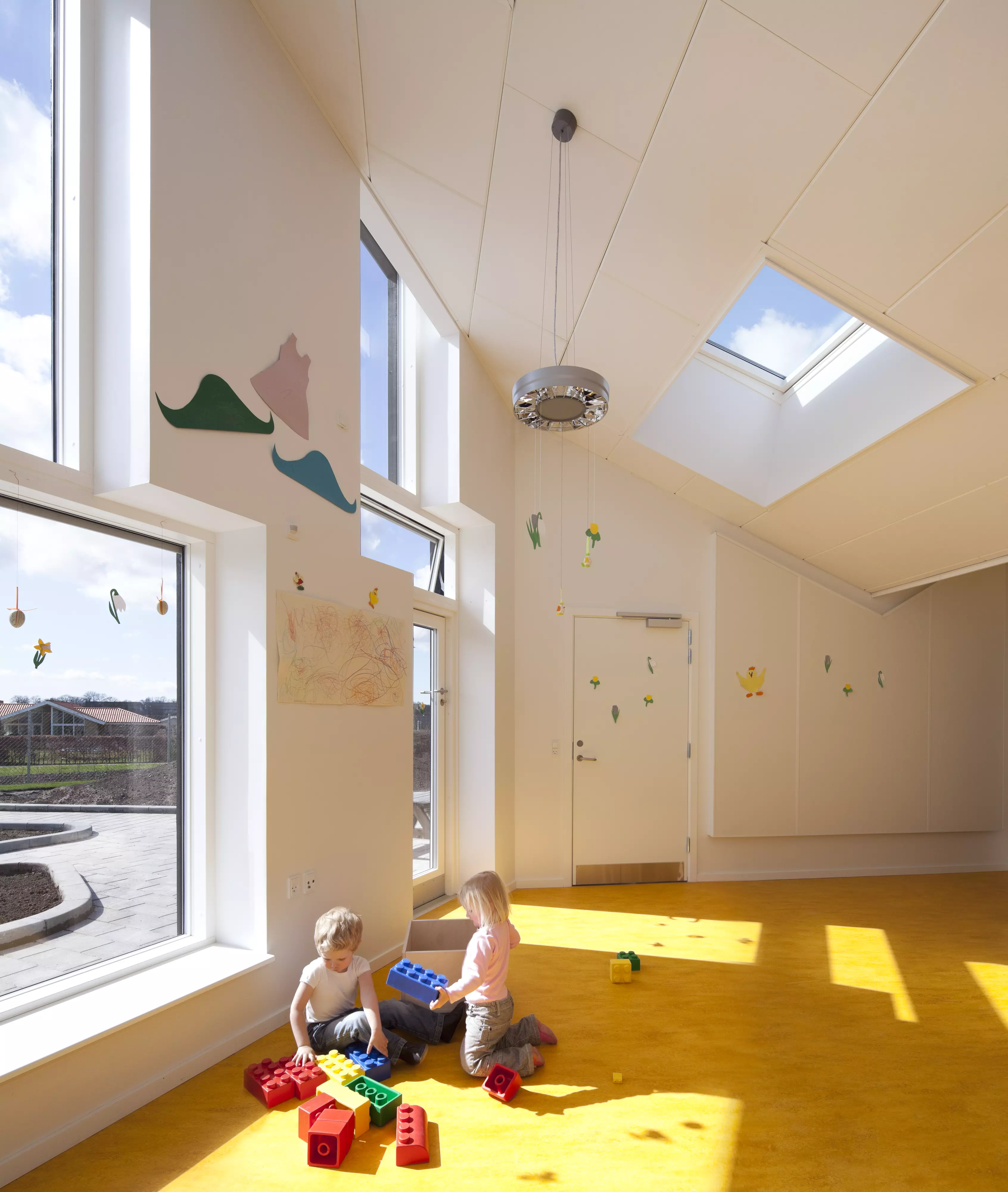 Children's playroom with sloped ceiling and VELUX roof windows, bright and colorful.