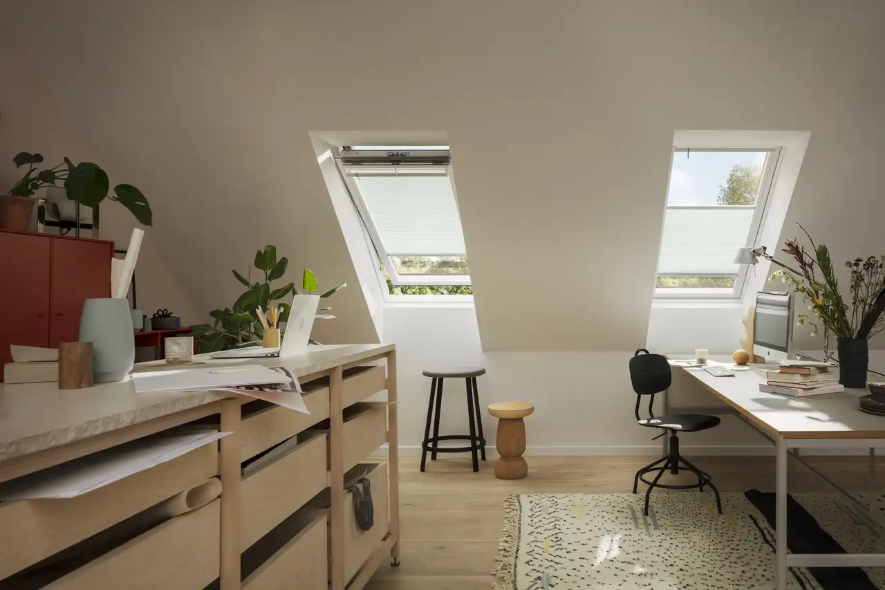 Bureau aménagé sous les combles avec fenêtres de toit VELUX, baigné de lumière naturelle.