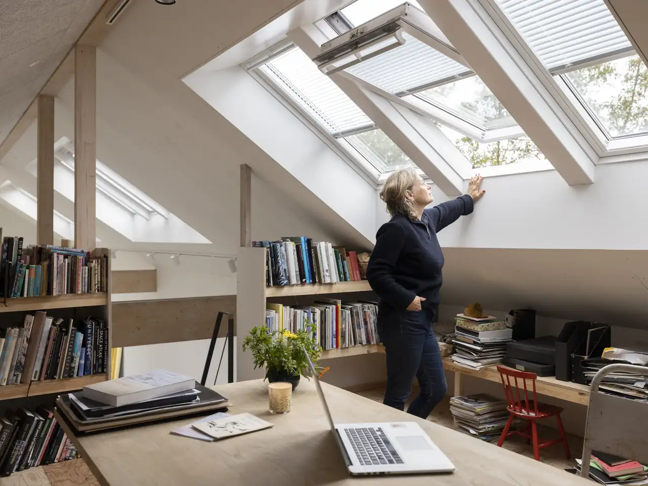 Frau steht am offenen Fensters ihres Home Office im Spitzboden | VELUX Magazin