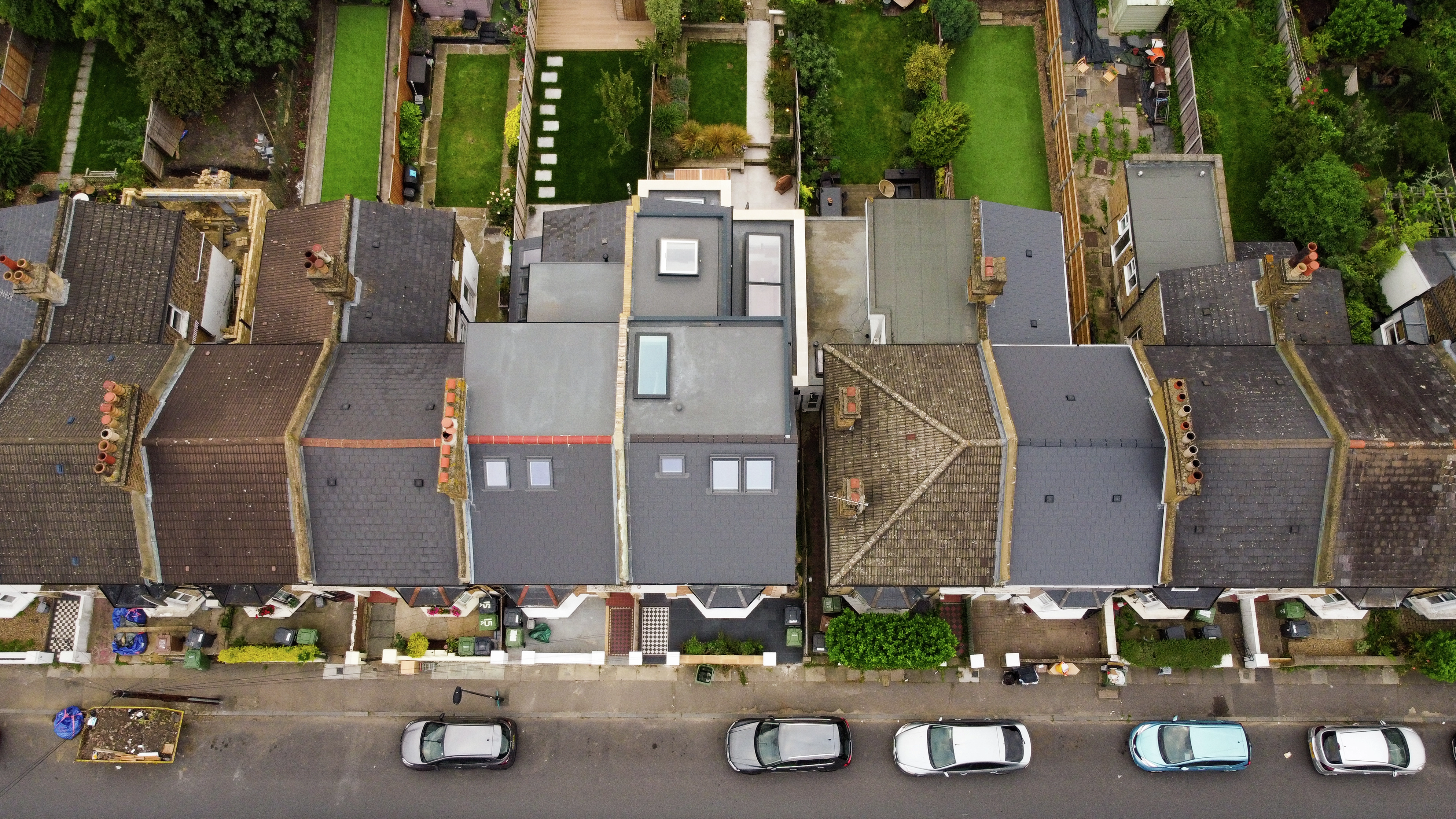 Aerial view of terraced houses with diverse roofing materials and VELUX roof windows.