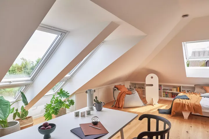 Gemütliches Dachboden-Schlafzimmer mit VELUX Dachflächenfenstern und minimalistischer Dekoration.