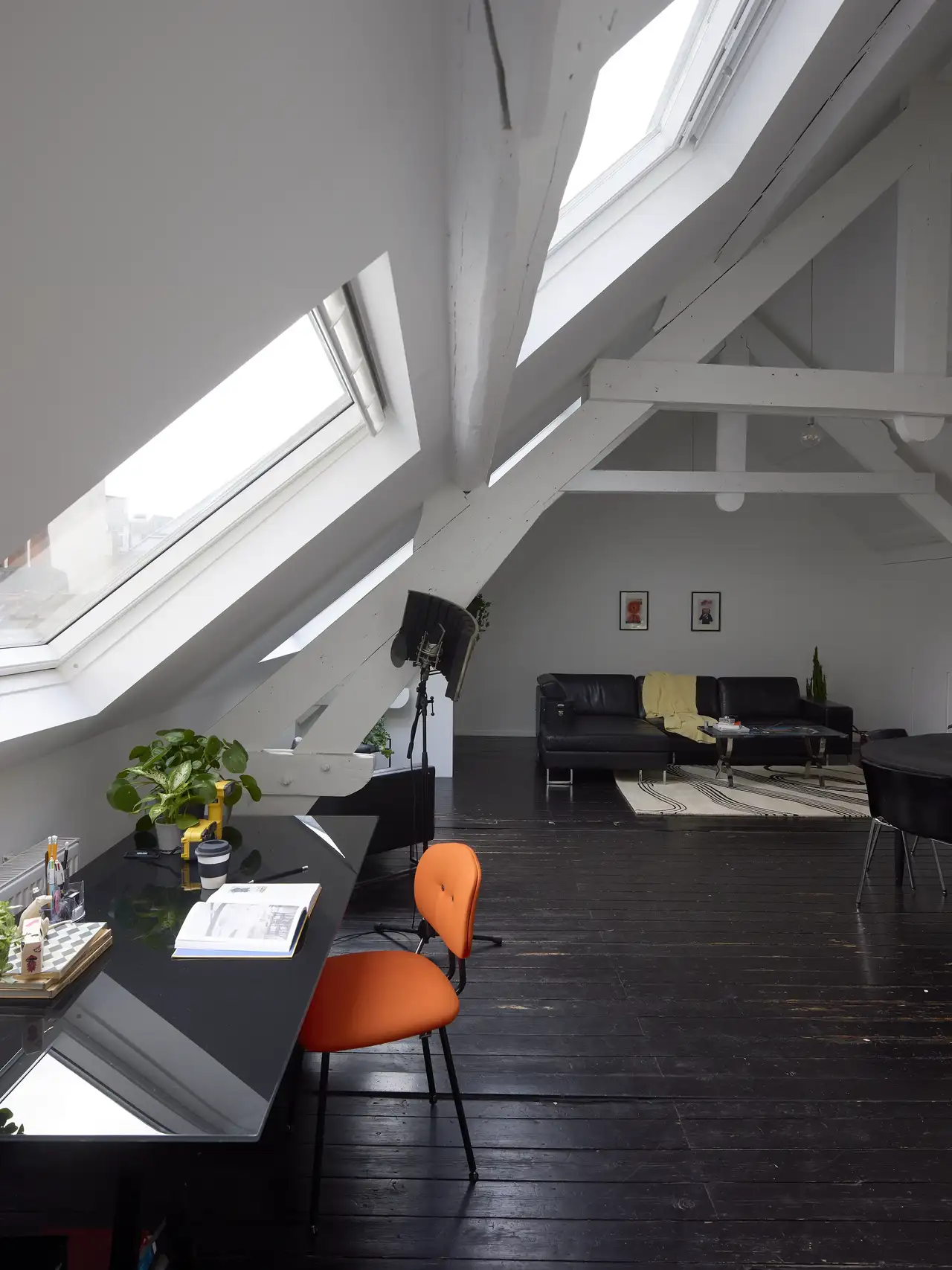 Bureau sous les toits avec murs blancs, sol noir et lucarnes | Magazine VELUX
