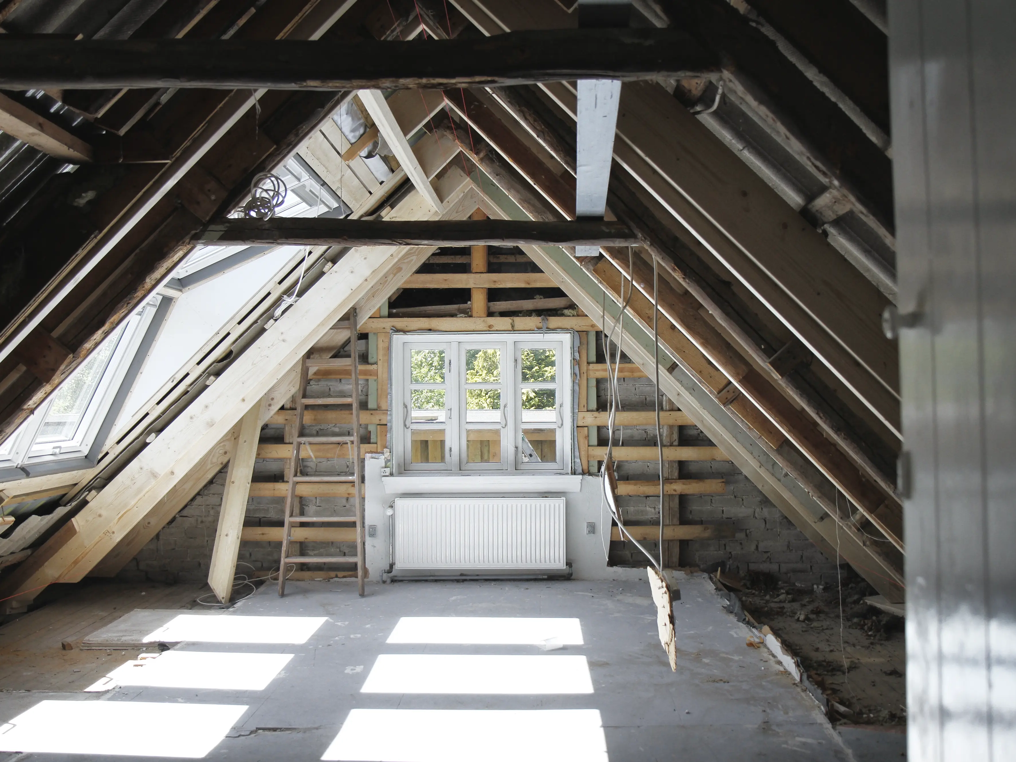 Renovated attic with visible rafters and VELUX roof window.