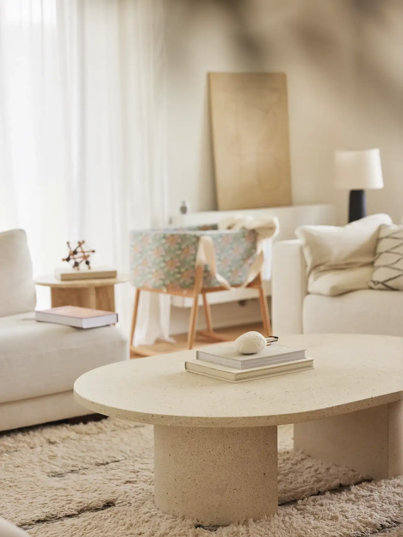 Living room with neutral decor, baby crib and natural light