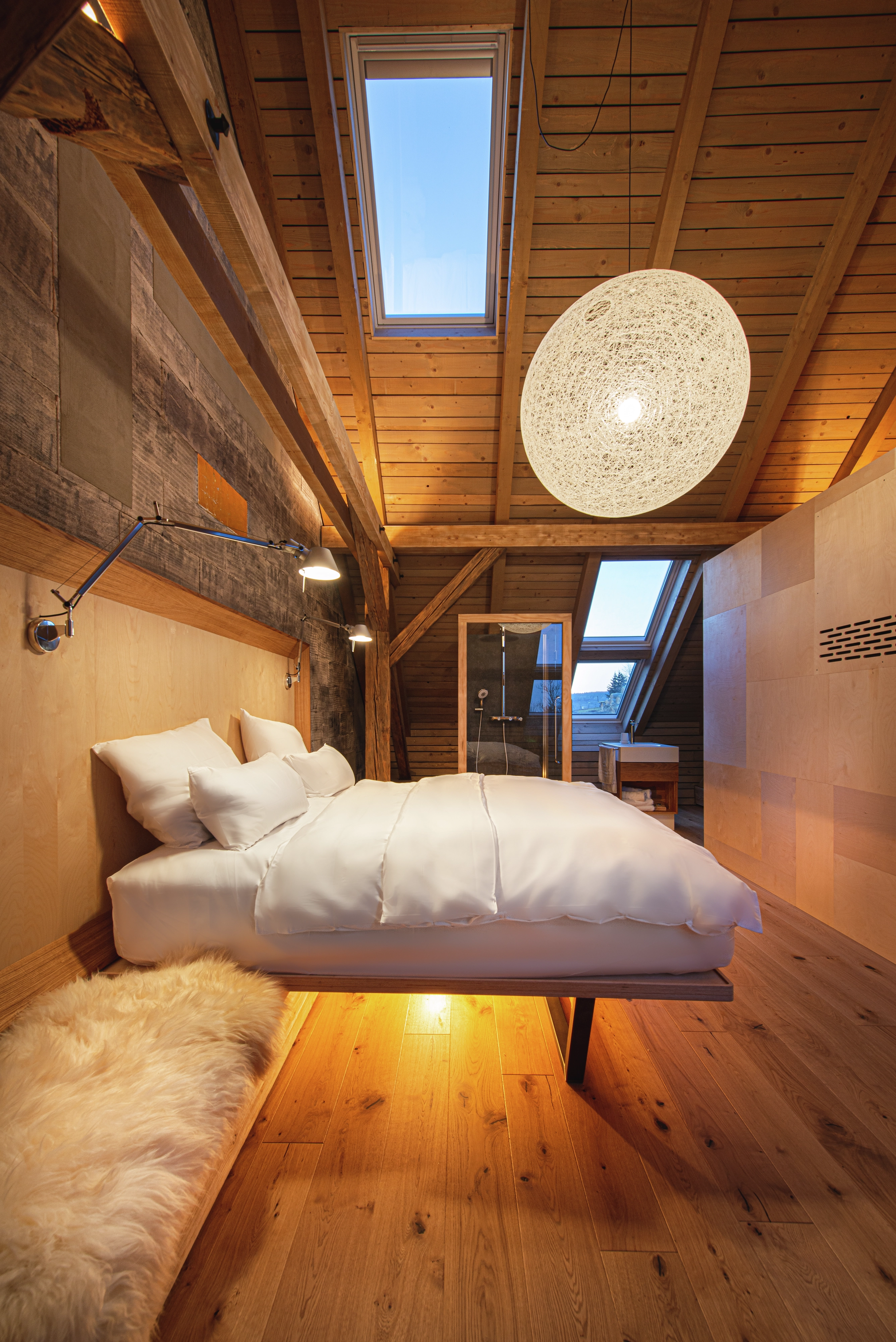 Attic bedroom with sloped ceiling, VELUX window, and cozy decor.