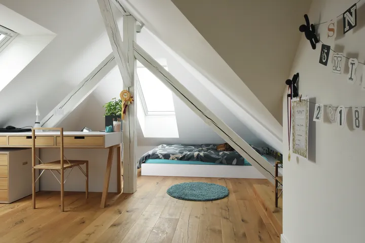 Helles Gästezimmer unterm Dach mit Schreibtisch und Doppelbett | VELUX Magazin