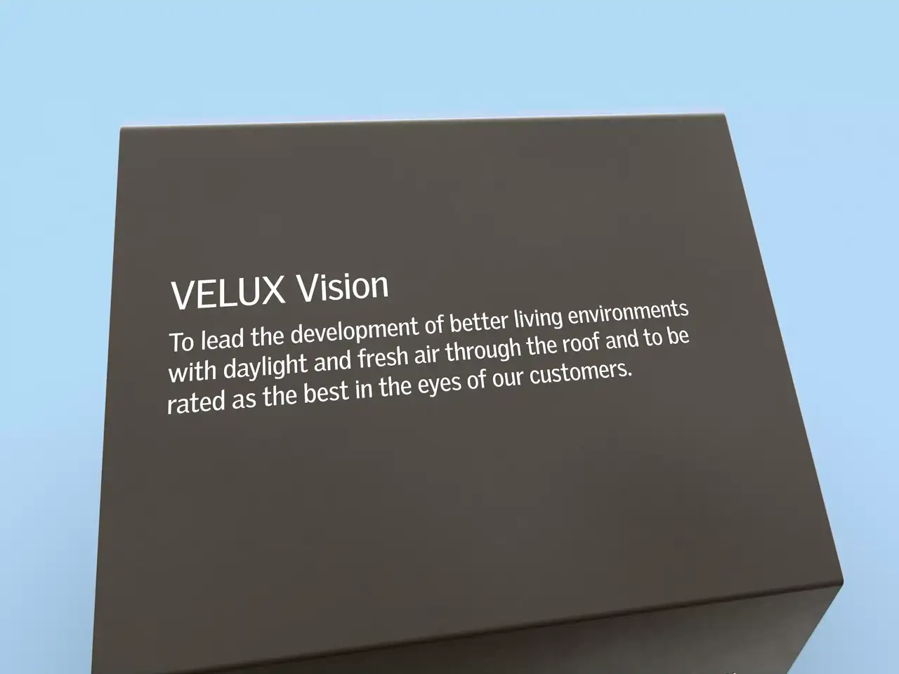 Nahaufnahme einer VELUX Vision-Box mit dem Markenversprechen für bessere Lebensumgebungen.