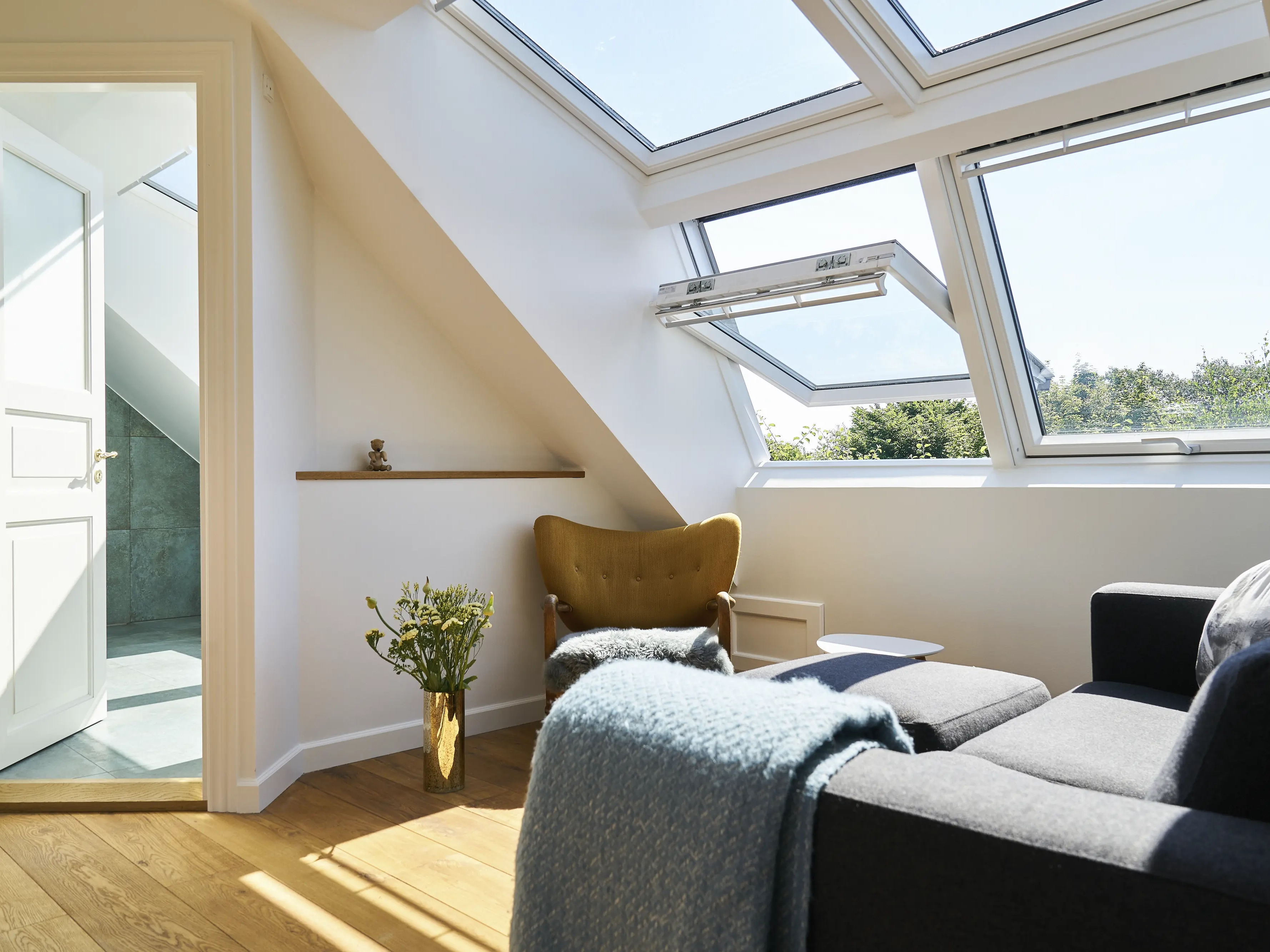 Attic living space with sloped ceiling and open VELUX roof windows.