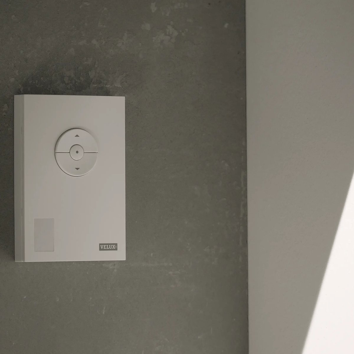 VELUX wall control panel on a textured wall, minimalist design.