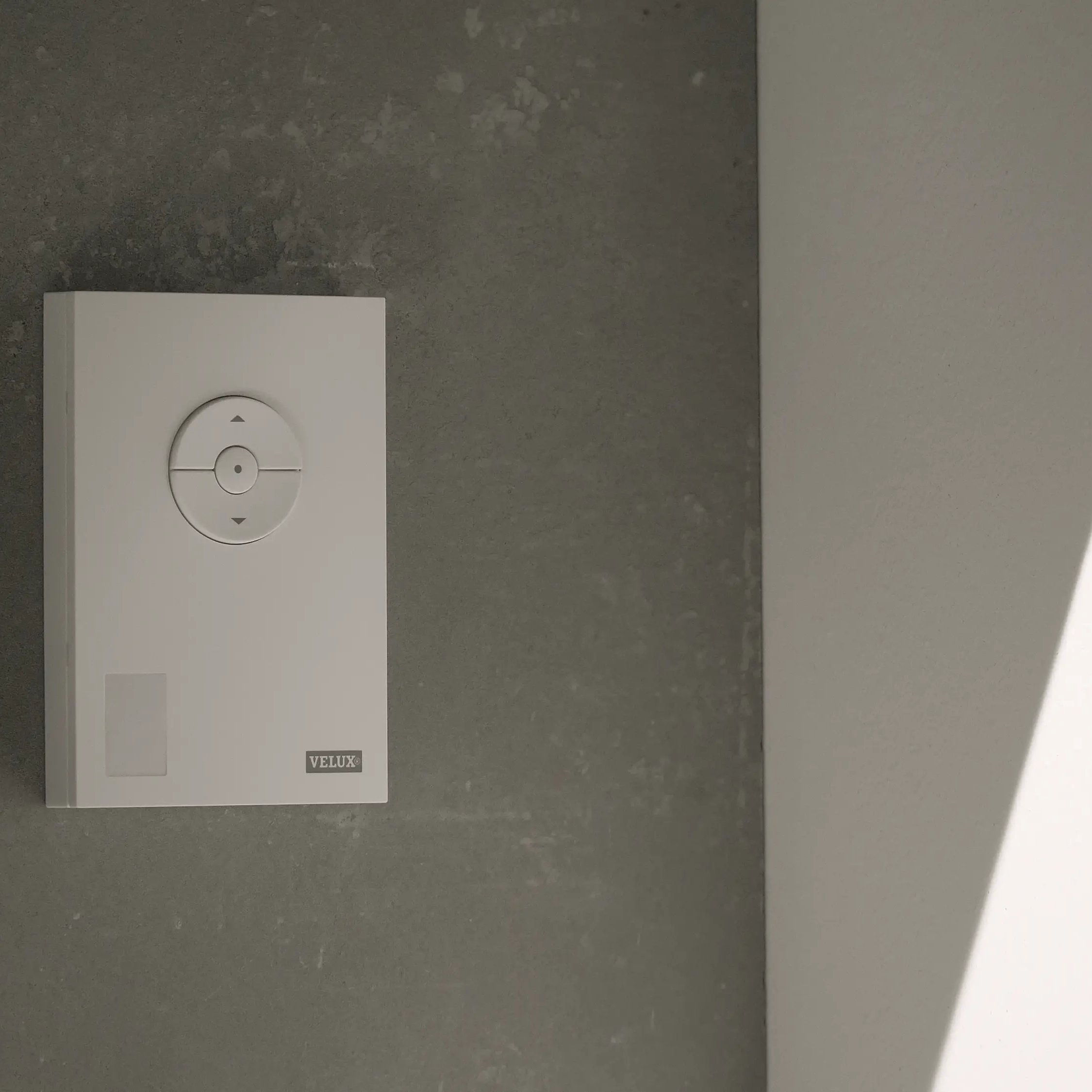 VELUX wall control panel on a textured wall, minimalist design.