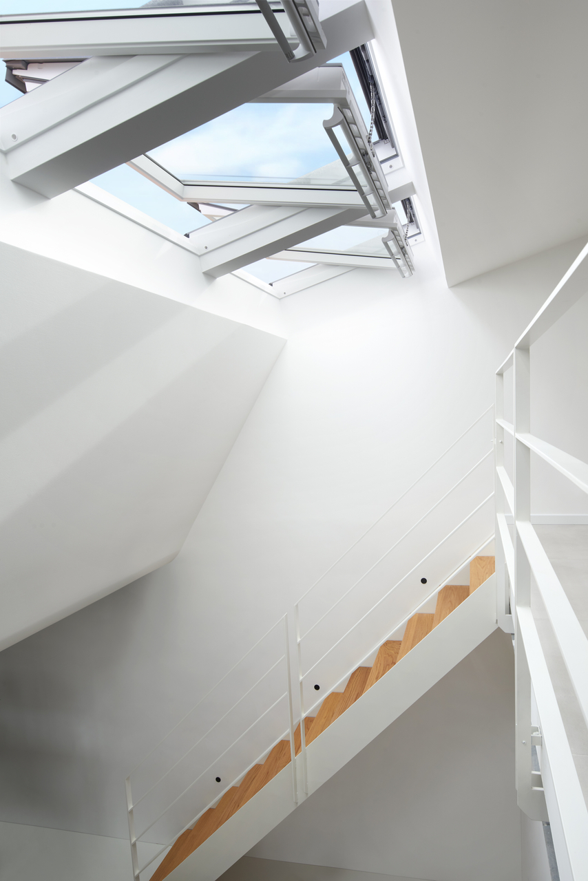 Finestre per tetti VELUX aperte su scala che conduce a soppalco.