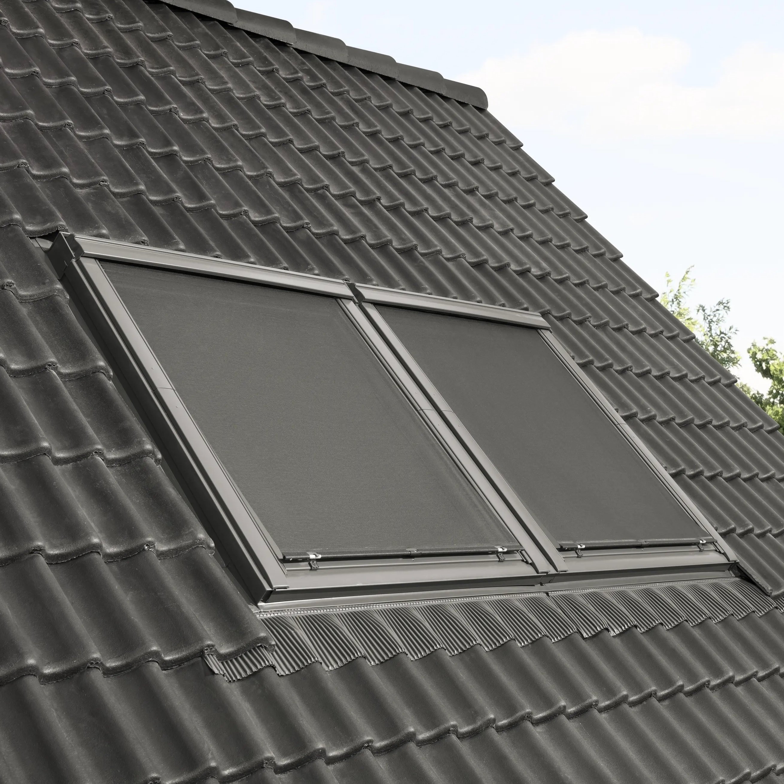 Modern roof with black tiles and closed VELUX roof windows.
