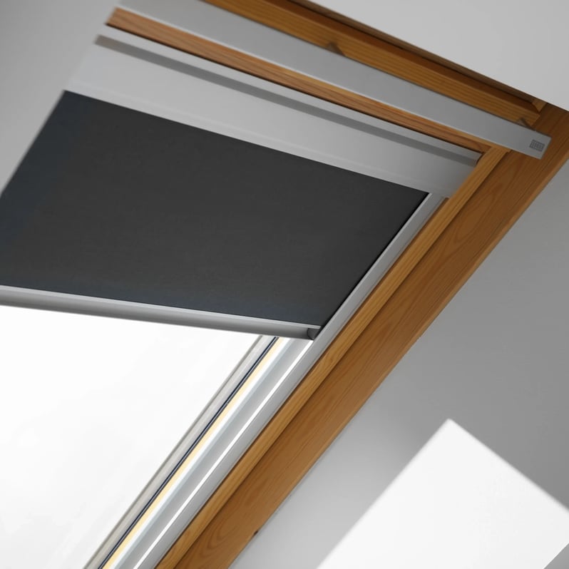 Close-up of VELUX roof window with wooden frame and dark blind.