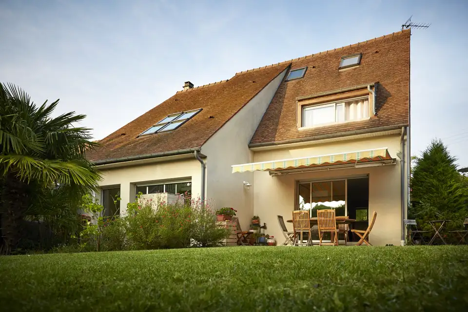 Maison contemporaine à toit en pente avec ouvertures zénithales et terrasse aménagée