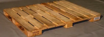 Wooden pallet on concrete floor, used for transporting goods.