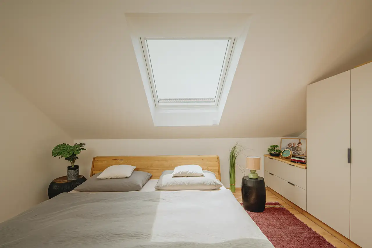 Futonbett im hellen Schlafzimmer mit Grünpflanzen unter Dachfenster | VELUX Magazin