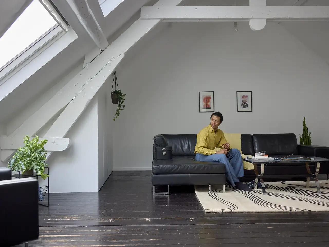 Sala decorada no sótão com teto inclinado, janelas de telhado VELUX e decoração moderna.