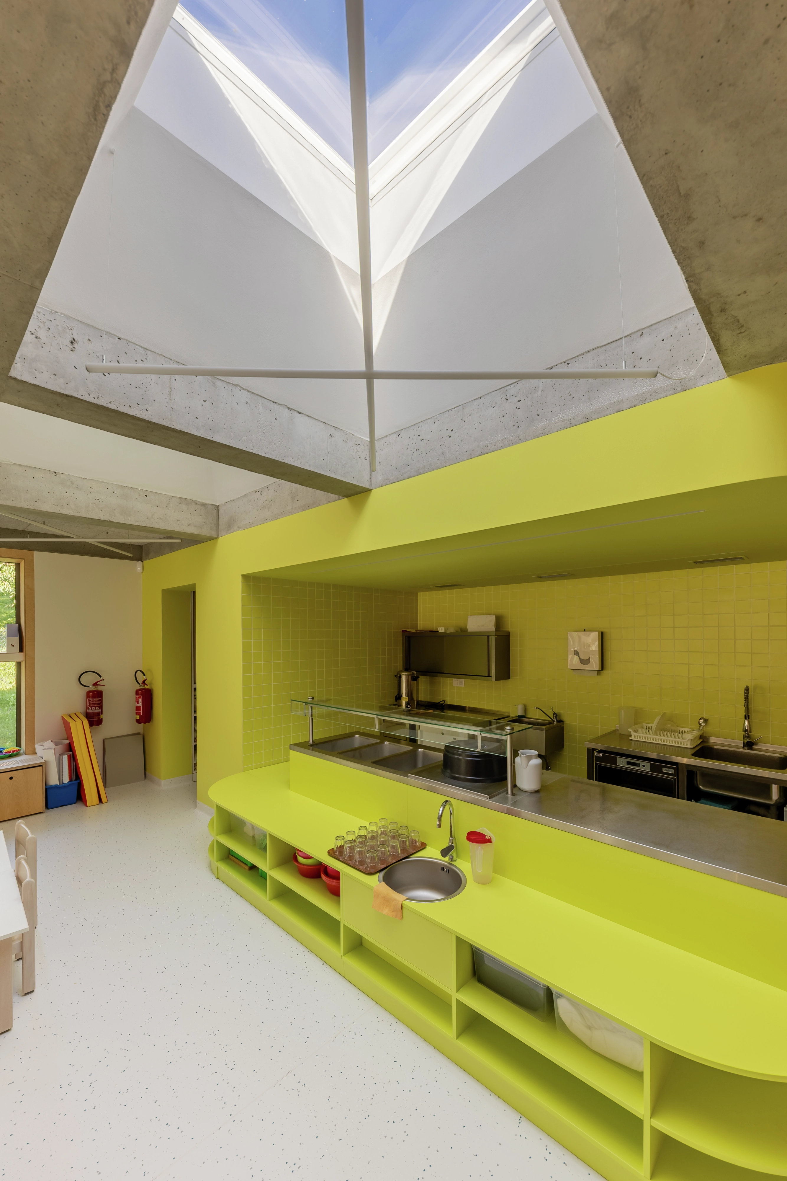 Modern kitchen with yellow accents and skylight.