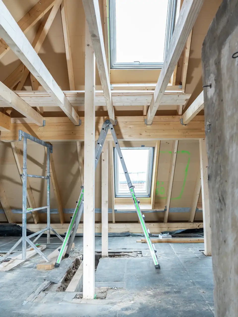 Attic under renovation with visible rafters and VELUX roof window. 