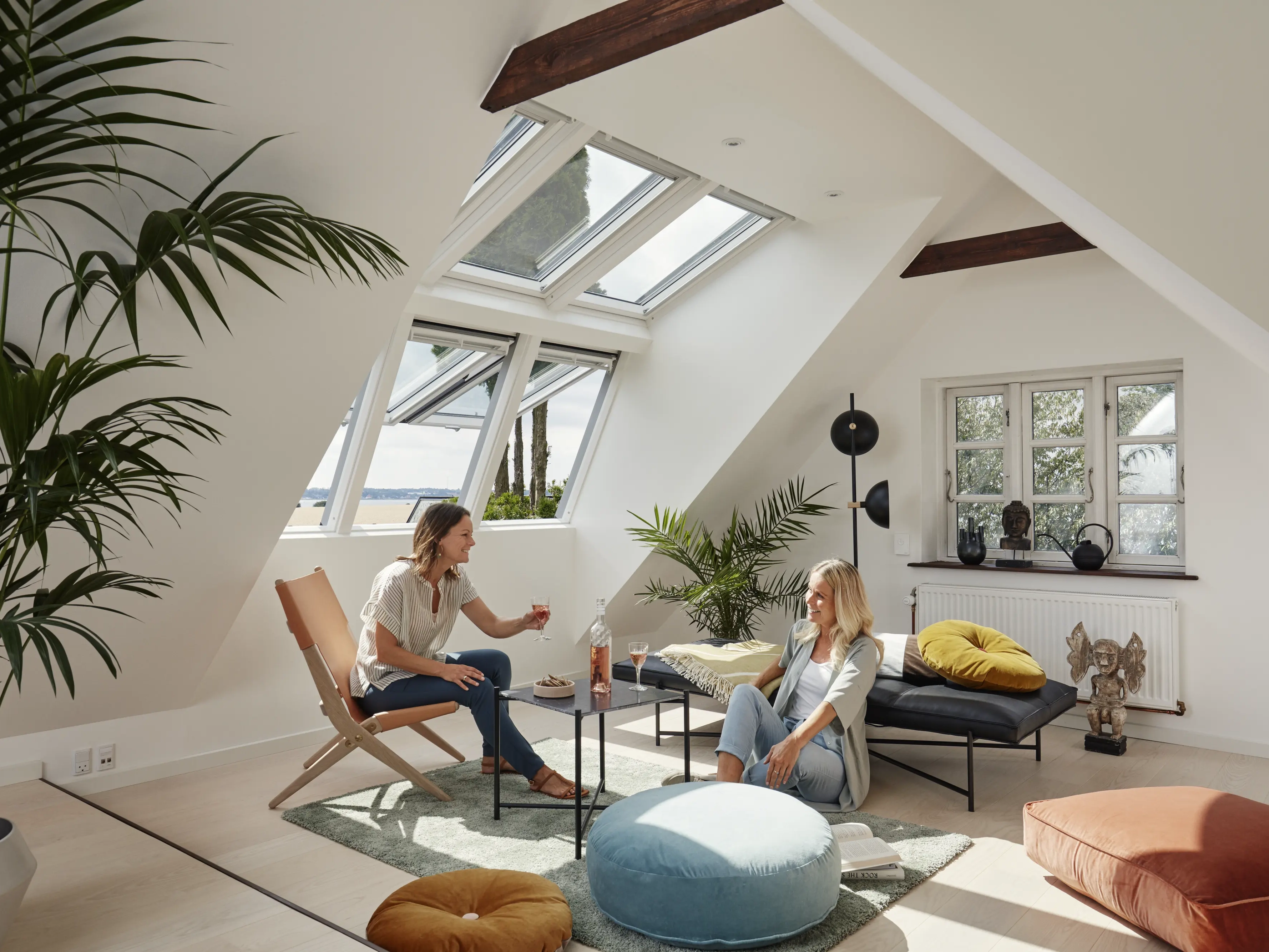 Attic living space with sloped ceiling and open VELUX roof windows.