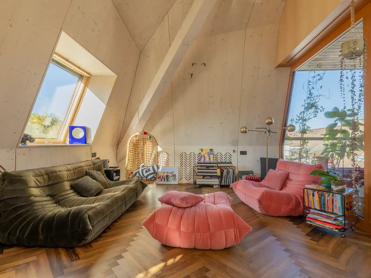 Séjour moderne avec canapés aux formes années 70 et lumière naturelle provenant de fenêtres de toit VELUX.